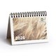 Desk calendar with spiral binding and stand-up base.